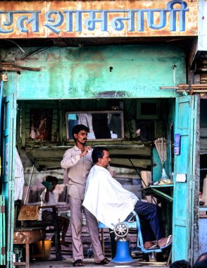 Bir berber, Jaipur, Rajasthan 'da bir berber dükkanında müşterisinin saçını kesiyor. Dükkan tipik bir yerel stil ve günlük yaşam gösteriyor..