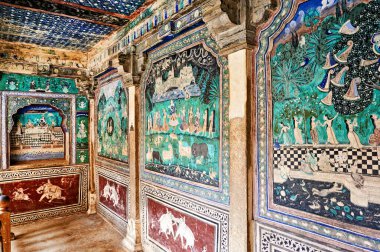 Ziyaretçiler Bundi, Rajasthan 'daki Taragarh Kalesi' ndeki renkli dekorasyon ve resimlere hayran. Sanat tarihi ve kültürü anlatır..