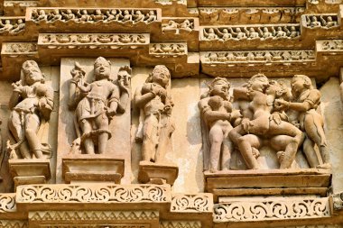 Ziyaretçiler, güneşli bir günde Hindistan 'ın Madhya Pradesh kentindeki Khajuraho tapınaklarında aşkı ve ilişkileri resmeden tarihi oymaları keşfediyorlar..