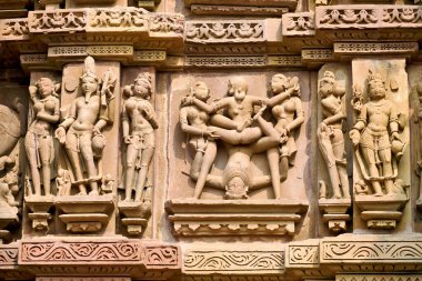 Taş duvarlardaki oymalar Khajuraho, Madhya Pradesh 'teki günlük yaşam ve erotizm sahnelerini gösteriyor. Ziyaretçiler bu tarihi tapınakları keşfediyorlar..