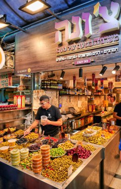 Kudüs 'teki Mahane Yehuda Pazarı' nda gün boyunca renkli zeytin ve atıştırmalıklar düzenleyen satıcılar görülüyor..