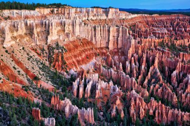 Gün doğumu Bryce Kanyonu Ulusal Parkı, Utah 'taki Bryce Point gözcülüğündeki kaya oluşumlarına ve ağaçlara ışık getirir. Gökyüzü ilk renkleri gösterir.