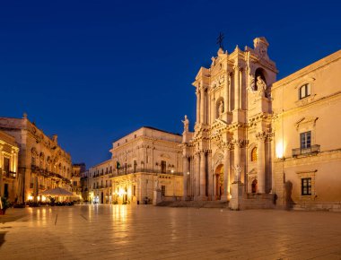 Ziyaretçiler Ortygia Adası 'ndaki Syracuse Katedrali' ne hayran kalırken, gece ışıkları tarihi mimarisini ve çevresindeki meydanı geliştiriyor..