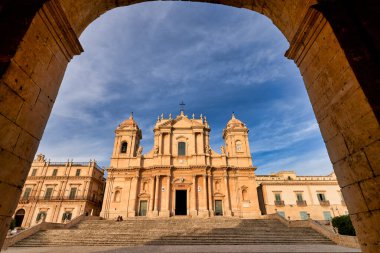 Sicilya 'daki Noto Katedrali' ni ziyaret eden turistler, açık mavi gökyüzü altındaki mimarisine hayran kaldılar. Merdivenler binanın büyük girişine çıkar..
