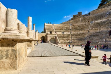 Ziyaretçiler Ürdün 'ün Amman kentindeki Roma Tiyatrosu' nda yürüyorlar. Antik yapıda koltuklar ve tarihi kalıntılar sergileniyor.