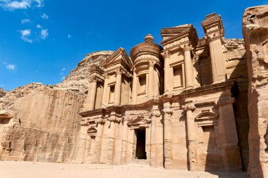 Ziyaretçiler, Petra 'daki Ad Deir' in büyük kaya kesimli yapısına hayran. Bu site, çöl ortamındaki antik mimari ve zengin tarihi gösteriyor..
