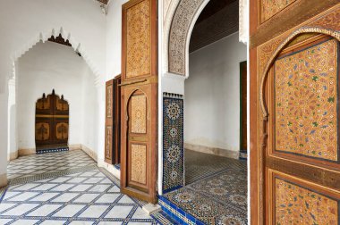 Ziyaretçiler Marakeş 'teki Bahia Sarayı' ndan geçiyorlar. İç kısımda renkli fayanslar ve ahşap kapılar var. Saray zengin mimari detaylara sahip..