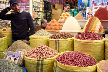 İnsanlar çeşitli baharat ve ürünler almak için Meknes 'teki çarşıda toplanıyorlar. Piyasanın her yerinde renkli baharat yığınları sergileniyor..