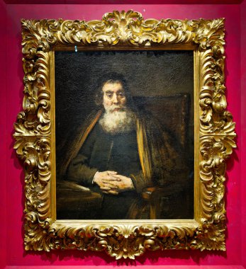 Bir haham sakin bir şekilde sandalyeye oturup ellerini birleştirir. Resim çerçevelenmiş ve Uffizi Galerisi, Floransa, İtalya 'da sergilenmektedir..