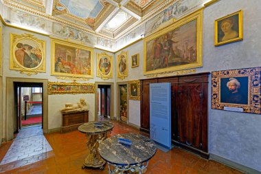 Ziyaretçiler Floransa, Toskana 'daki Casa Buonarroti' yi keşfe çıkarak, odanın içindeki sanat ve tarihi ayrıntıları inceliyorlar. Boşlukta resimler ve dekorasyon var..