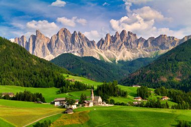 Val di Funes Güney Tyrol, İtalya 'da. Sergide Dolomitler ve vadide yeşil tarlaları olan küçük bir köy yer alıyor..