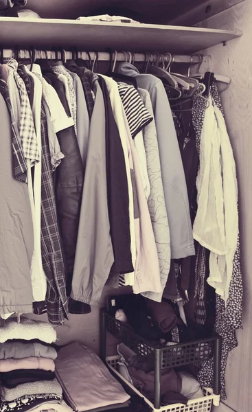 Färgglada kläder hängande i garderob - vintage stil Stockbild