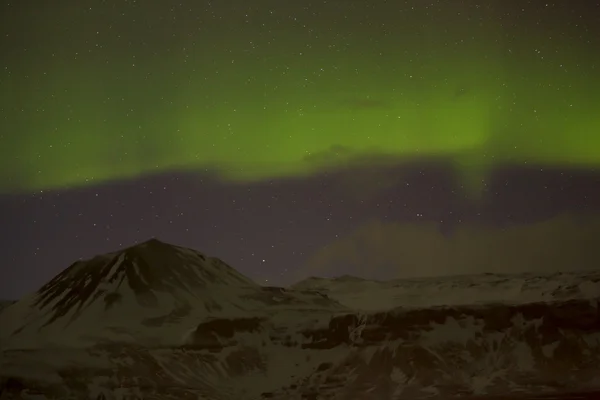 Luces boreales con montañas nevadas en primer plano —  Fotos de Stock