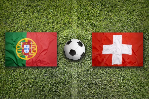 Португалия против Швейцарии флаги на футбольном поле — стоковое фото