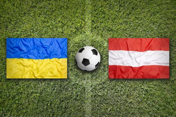 Прапори України проти Австрії на футбольному полі — стокове фото
