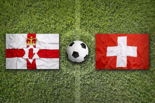 Прапори Північної Ірландії проти Швейцарії на футбольному полі — стокове фото