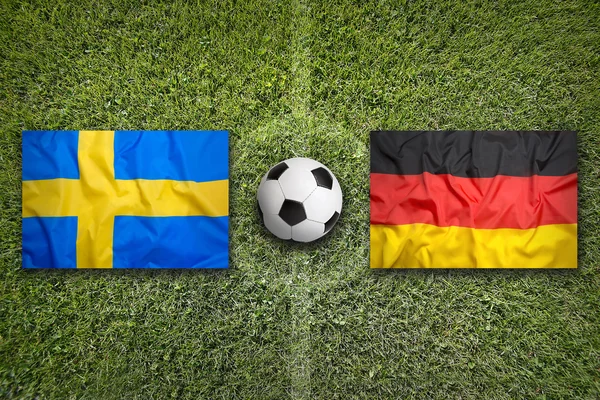 Sweden vs. Germany flags on soccer field — Stock Photo, Image