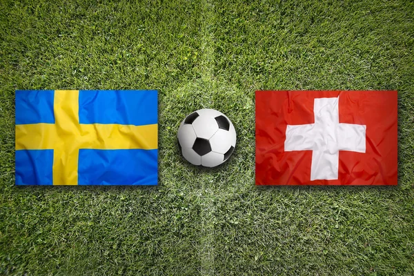 Швеція проти Швейцарії прапори на футбольному полі — стокове фото