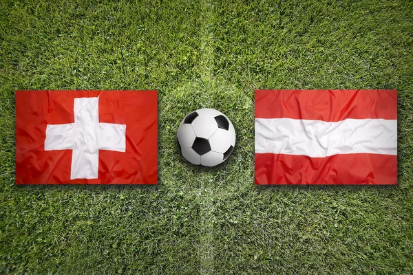 Швейцарія проти Австрії прапори на футбольному полі — стокове фото