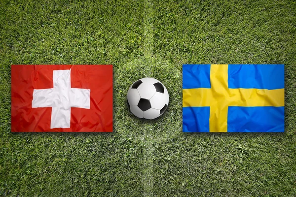 Ελβετία vs. Σουηδία σημαίες σε γήπεδο ποδοσφαίρου — Φωτογραφία Αρχείου