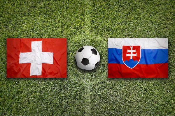 Schweiz vs Slovakien flaggor på fotbollsplan — Stockfoto