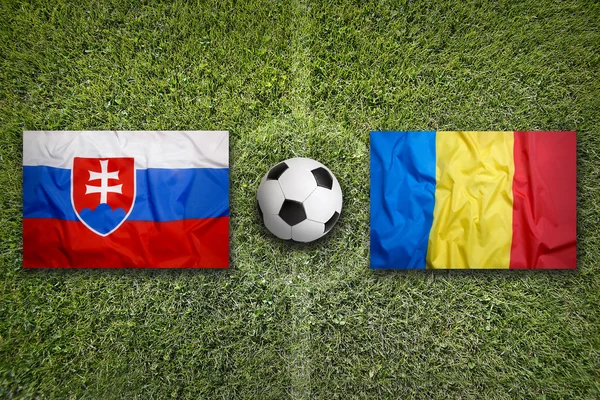 Slovakien vs Rumänien flaggor på fotbollsplan — Stockfoto