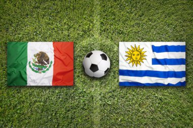 Uruguay vs Meksika futbol sahası üzerinde bayraklar