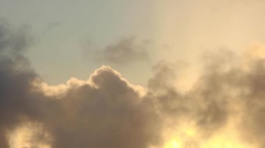 Zaman atlamalı bir gün batımında sarı bulutlar