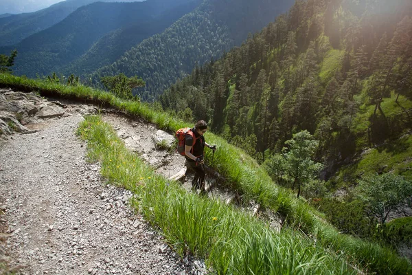 バイエルンアルプスの山々で赤いハイキングバックパックを持つ女性のハイキング — ストック写真