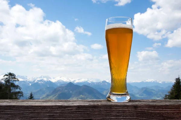 バイエルンの山の景色のパノラマの前にある麦酒グラス — ストック写真