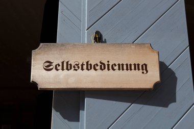 Dağ kulübesinde kendi kendine hizmet eden bir tabela.