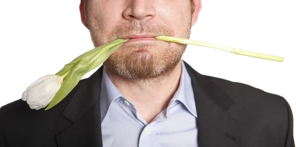 En mann som holder tulipan i munnen – stockfoto