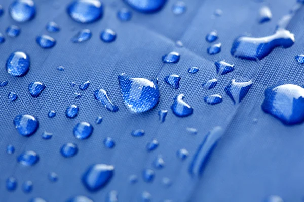 Primer plano de las gotas de lluvia en un paraguas azul — Foto de Stock