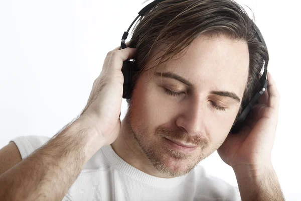 Hombre atractivo con auriculares delante de un fondo blanco es — Foto de Stock