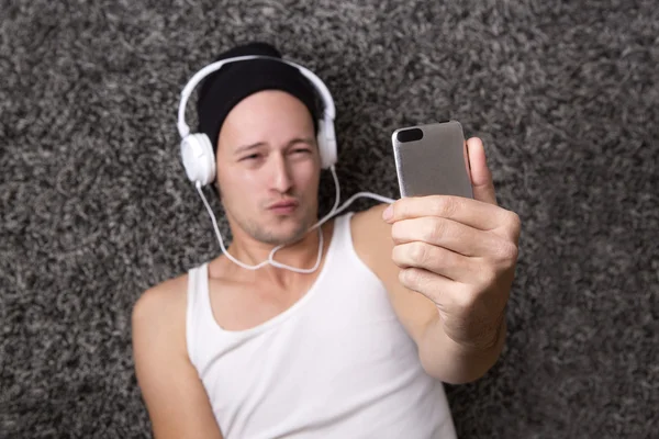 Attractive man with headphones makes selfie with his mobile — Stock Photo, Image