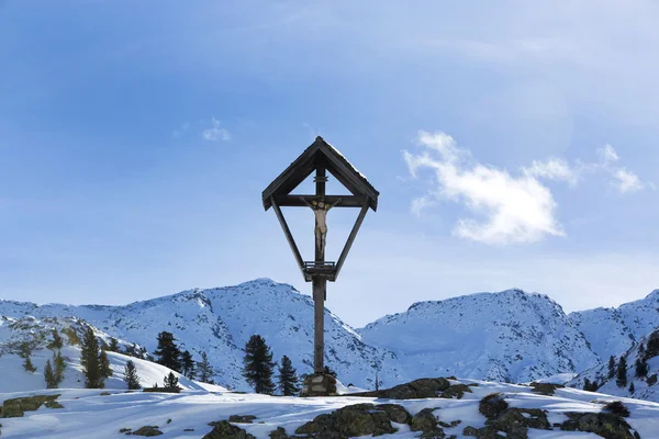 Cross in snowy mountain landscape — Stock Photo, Image