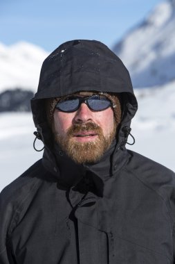 Karlı dağ manzarası genç adam kameraya benziyor