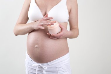 Hamile kadının karnı üzerinde krem koymak