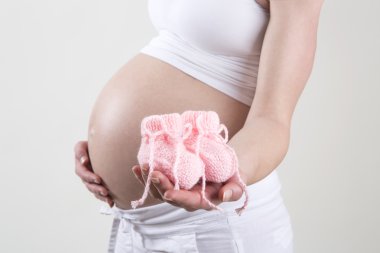 Pembe Bebek Patiği onun elinde tutan hamile kadın