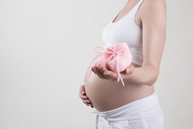 Pembe Bebek Patiği onun elinde tutan hamile kadın