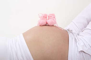 Pembe Bebek Patiği karnı üzerinde olan hamile kadın