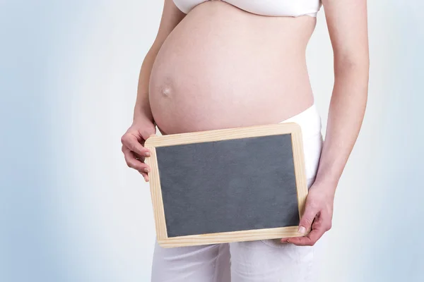 Zwangere vrouw met een leeg bord — Stockfoto