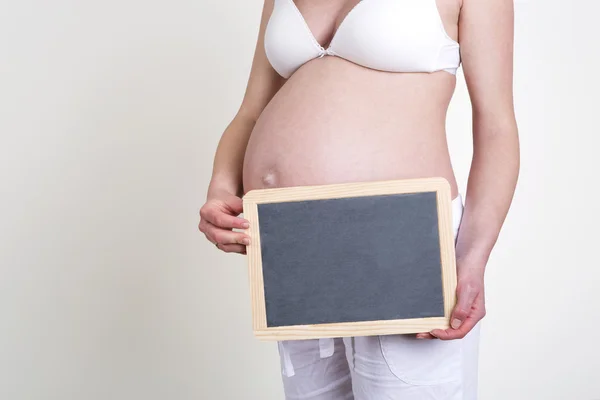 Zwangere vrouw met een leeg bord — Stockfoto