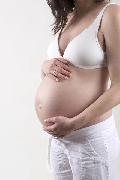 Mulher grávida na frente de um fundo branco — Fotografia de Stock