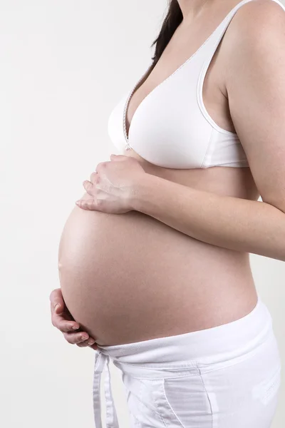 Mulher grávida na frente de um fundo branco — Fotografia de Stock