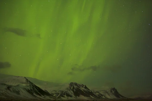 Luces boreales con montañas nevadas en primer plano —  Fotos de Stock