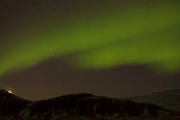 Luces boreales con montañas nevadas en primer plano —  Fotos de Stock