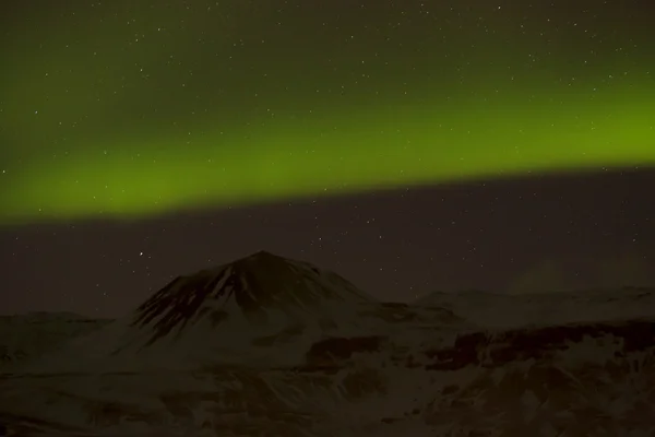 Luces boreales con montañas nevadas en primer plano —  Fotos de Stock