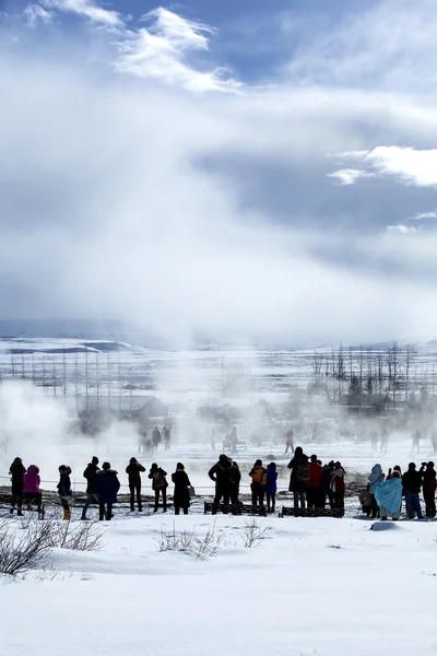 Visitantes observando a erupção de um gêiser na Islândia — Fotografia de Stock
