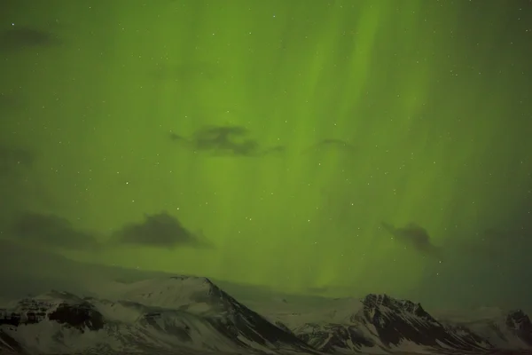 Luces boreales con montañas nevadas en primer plano —  Fotos de Stock